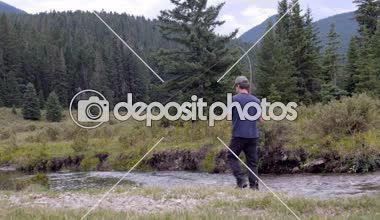 Bir sporcu bir nehir sinek balıkçılık bir balık yakalar