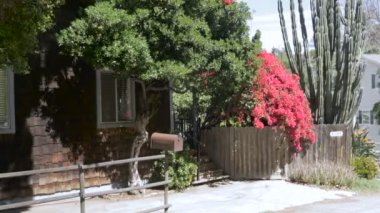 Büyük kırmızı begonviller ve ahşap zona ile bir ev kurulması