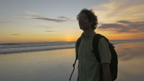 Μπροστινή θέα ενός άντρα που απολαμβάνει τη θέα στο ηλιοβασίλεμα του ωκεανού στο Μπαλί — Αρχείο Βίντεο