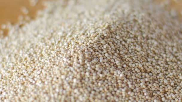 Close up van ongekookte quinoa draaien op een houten snijplank — Stockvideo