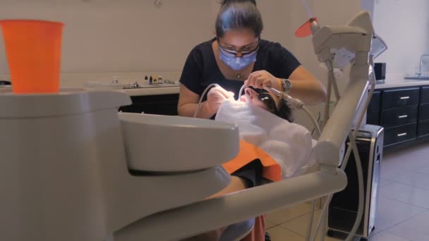 患者さんの歯のクリーニング、ヒスパニック系の歯科医のドリー ショット — ストック動画