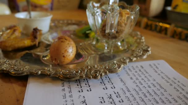 Sinek üzerinde tipik bir Fısıh seder tabağı ve Haggadah — Stok video