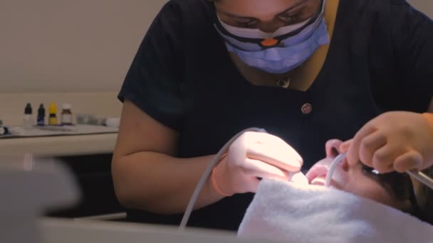 Detailní záběr žena zubař pracuje na člověka v ústech — Stock video