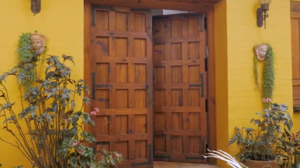 Una atractiva mujer mayor abre su puerta para saludar a los invitados y sonríe — Vídeos de Stock