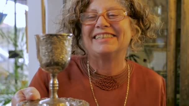 Приваблива старша єврейська жінка пояснює чашку кіддуша — стокове відео