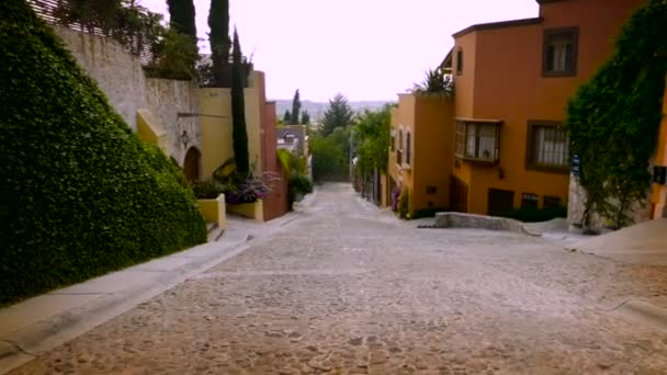 Steadicam αργή κίνηση ενός cobble πέτρα δρόμο με πολύχρωμα σπίτια και αυτοκίνητα δεν — Αρχείο Βίντεο