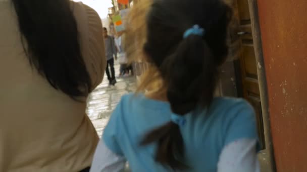 Egy fiatal család együtt sétál a keskeny utcákon a koloniális város — Stock videók