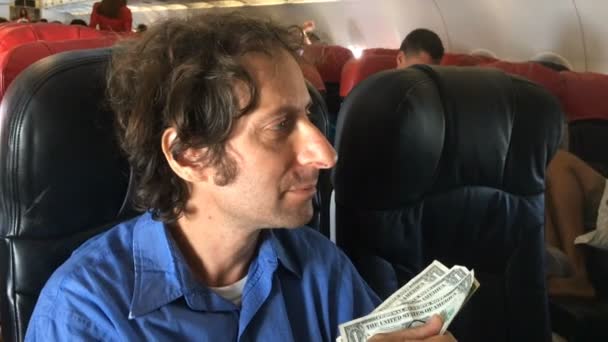 A frustrated traveler has trouble buying something with cash on a airplane — Stock Video