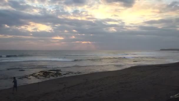 Time lapse di persone che giocano sulla sabbia in spiaggia durante il tramonto a Bali — Video Stock