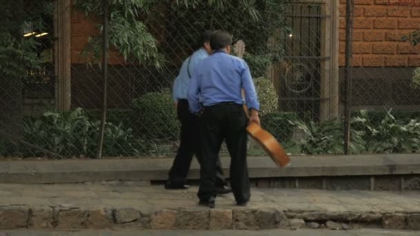 Two guitarist musicians walk down the street in slow motion — Stock Video