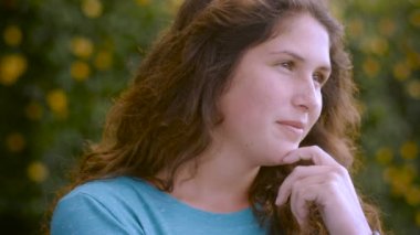 Mütevazı bir gerçek genç gülümsüyor ve kameradan uzağa bakarak gülüyor