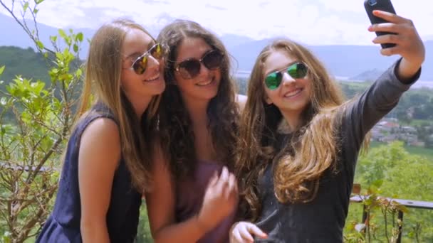 Девочки-подростки делают селфи и смотрят на свой мобильный в медленном темпе — стоковое видео