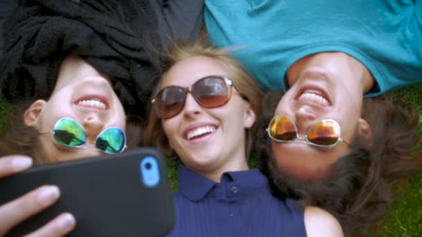 Three best friends take a selfie while lying next to each other in slow motion — Stock Video