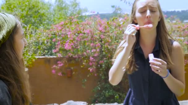 Two sisters playing with bubbles and having fun outside in slowmo — Stock Video