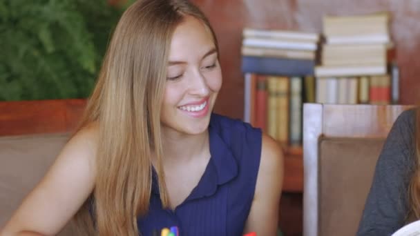 Three beautiful teenage girls work together on their homework — Stock Video