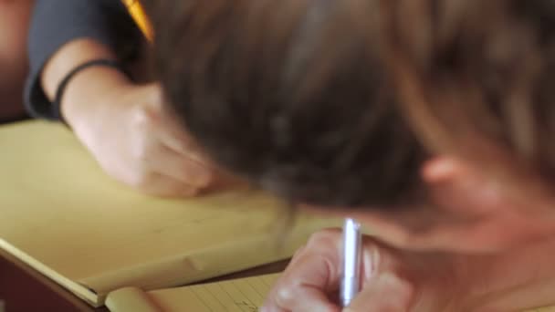 Kantelen van close-up van jonge tiener meisjes schrijven en huiswerk samen — Stockvideo