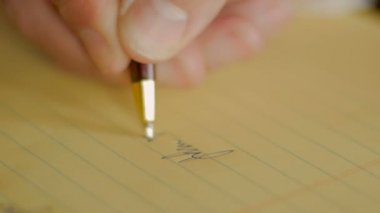 Portre kişinin adı üstünde sarı defter kalem ile imzalama