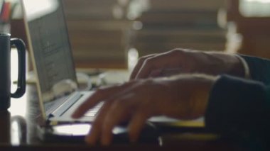 Adam tipik dizüstü klavye üzerinde ve cep telefonu coffee House kontrol