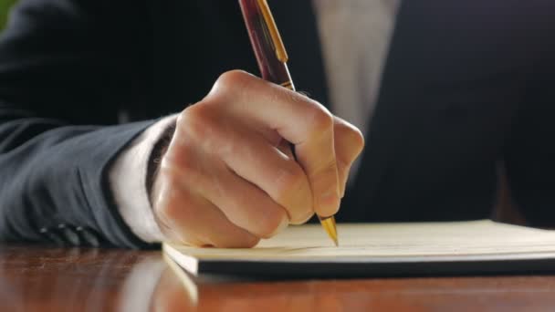 Primer plano del hombre de negocios escribiendo en cuaderno con pluma — Vídeos de Stock