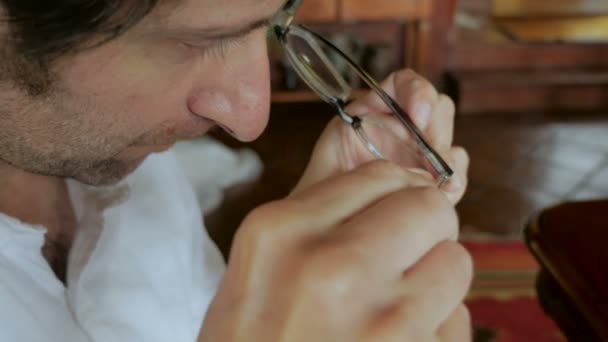 Man repairs glasses with tiny screwdriver - handheld — Stock Video
