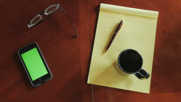 Kopf des Mannes am Schreibtisch mit Handy mit grünem Bildschirm Kaffee trinken — Stockvideo