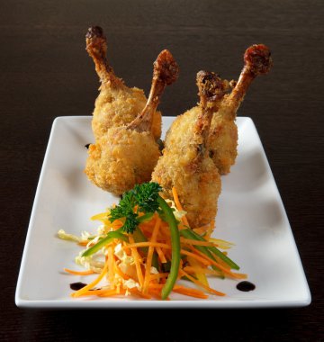 Kara-yaş. Kızarmış tavuk bacakları ekmekli ve vejetaryen garnitür sos ile. D