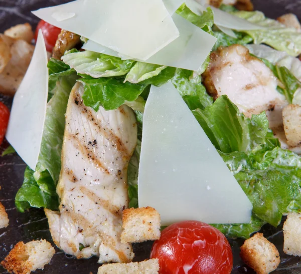 Macro fragmento de ensalada con carne de pollo a la parrilla, lechuga, tomates y croutons . —  Fotos de Stock