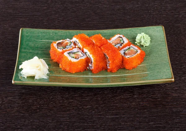 Sushi rola em um prato com ovas de peixe voador — Fotografia de Stock