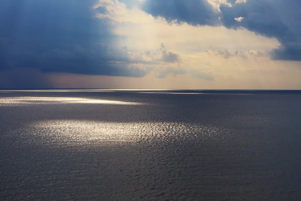 Cloudy seascape after storm seeing natural sunbeams at sunset. Stock Picture