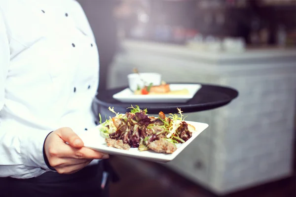 Camareros llevando platos con plato de carne en una boda — Foto de Stock