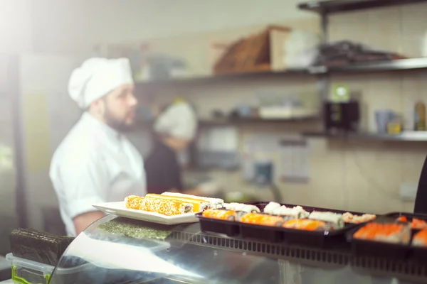 Hankockar som lagar sushi i restaurangköket — Stockfoto