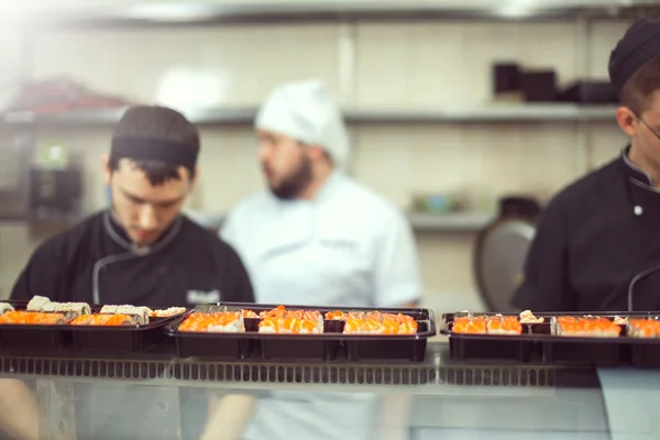 Male cooks preparing sushi in the restaurant kitchen — Stock Photo, Image