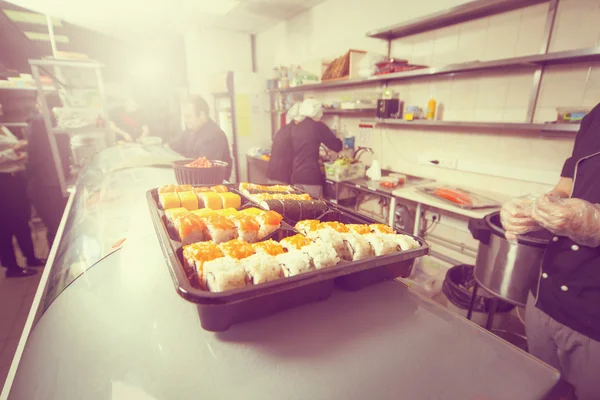 Male cooks preparing sushi in the restaurant kitchen — Stock Photo, Image