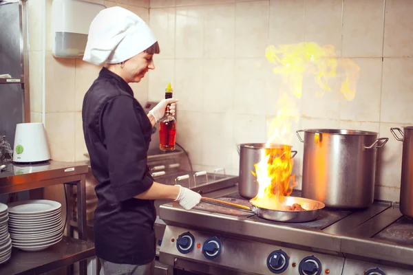 Шеф-повар готовит с огнем в сковороде — стоковое фото
