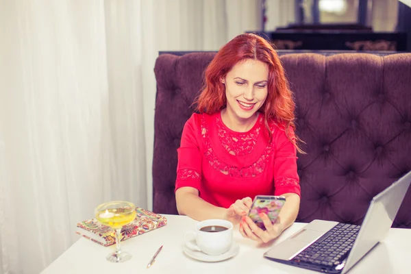 Красивая женщина с помощью ноутбука, телефон за столом в кафе — стоковое фото