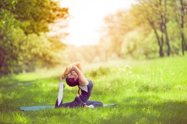 Sabah parkında yoga yapan genç bir kadın.