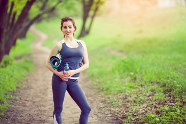 Sabah parkında yoga yapan genç bir kadın.