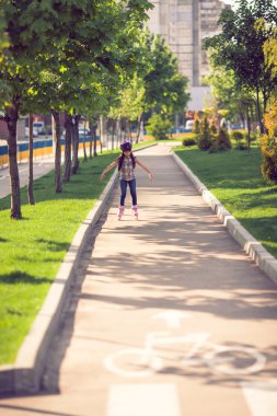 Çekici genç kız parkta paten