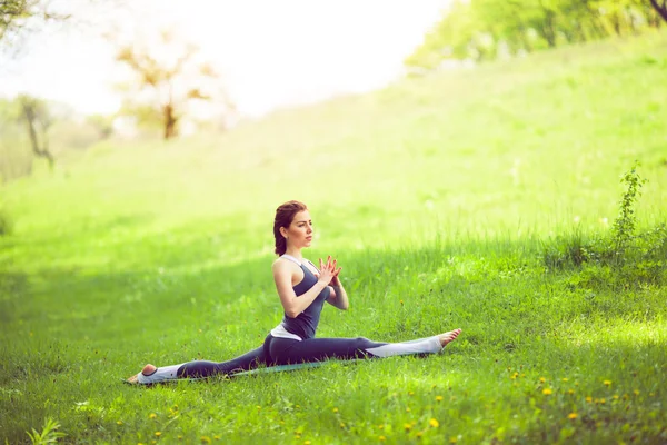 Jeune femme faisant du yoga dans le parc du matin — Photo