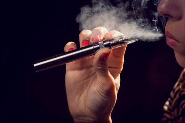 Close up of a woman inhaling from an electronic cigarette — Stock Photo, Image