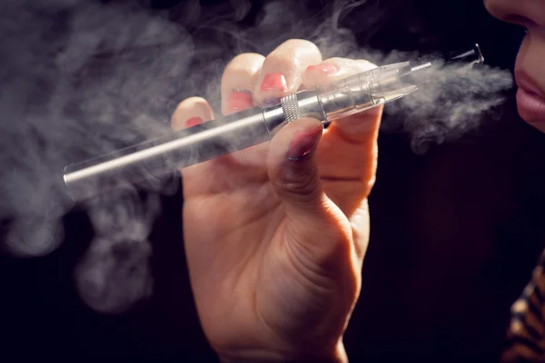 Close up of a woman inhaling from an electronic cigarette — Stock Photo, Image