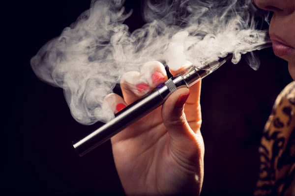 Menutup seorang wanita menghirup dari rokok elektronik — Stok Foto