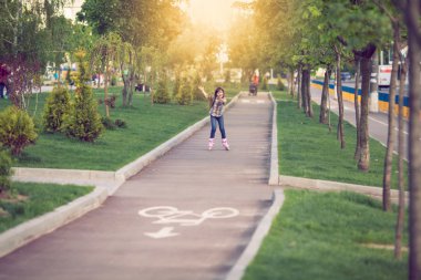 Çekici genç kız parkta paten