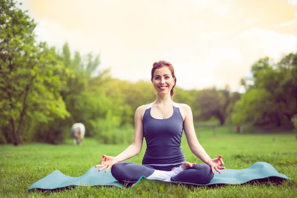 Young woman doing yoga in morning park. — Stock Photo, Image