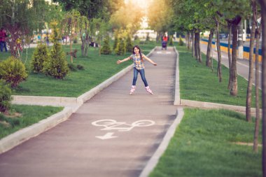 Çekici genç kız parkta paten.