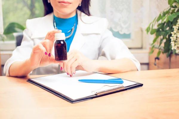 Close-up of doctor's hands writing prescription and holding bott — Stock Photo, Image