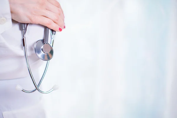 Retrato de una joven doctora con un abrigo blanco de pie en hosp — Foto de Stock