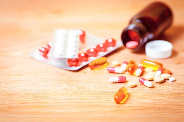 Χάπια σε ένα μπουκάλι σε ξύλινα φόντο, φάρμακο για τη θεραπεία — Φωτογραφία Αρχείου