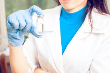 İlaç şişesi elinde, avucunun içinde bir doktor enjeksiyon için.