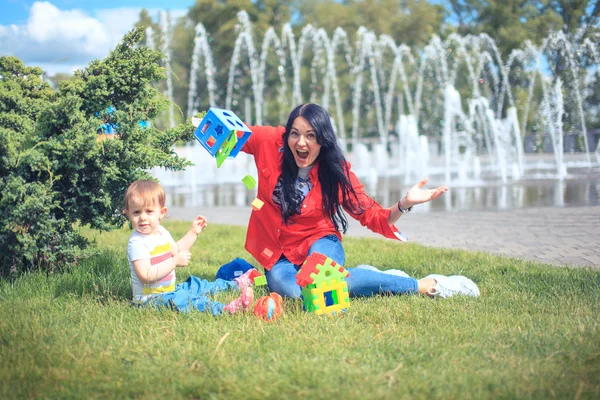 Young mother and her little baby daughter building tower with to — Stock Photo, Image